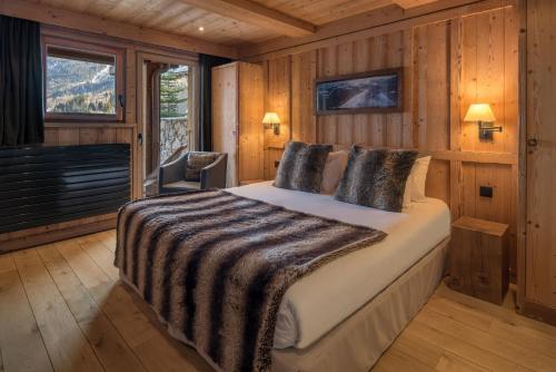 een slaapkamer met een bed in een blokhut bij Les Granges d'en Haut - Chamonix Les Houches in Les Houches