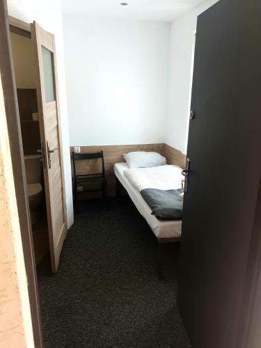 a small bedroom with a bed and a door open at BoomerangHouse in Wrocław