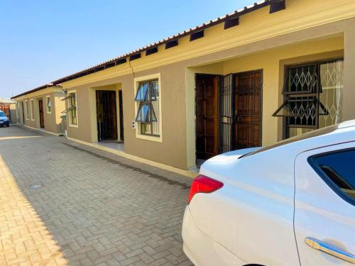 a white car parked in front of a building at Agnes Guest House in Germiston