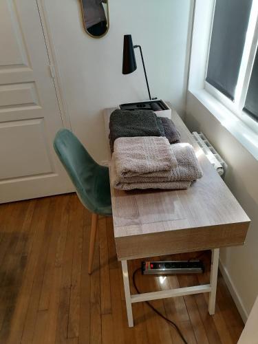 - une table avec des serviettes et une chaise verte dans l'établissement Villa des Roses - Appart T2, 32m2, RDC, vue sur jardin, 