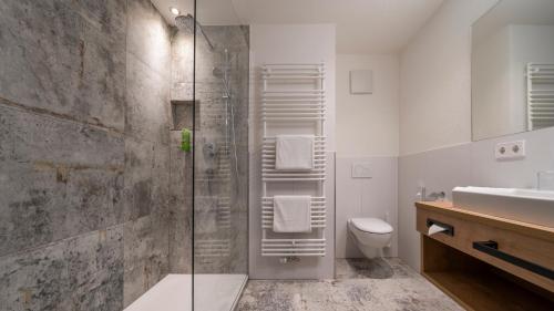 a bathroom with a shower and a toilet and a sink at Hotel Lipprandt in Wasserburg