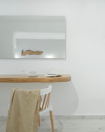 a table with a chair and a picture on the wall at Mykonos Essence Adults Only in Ornos