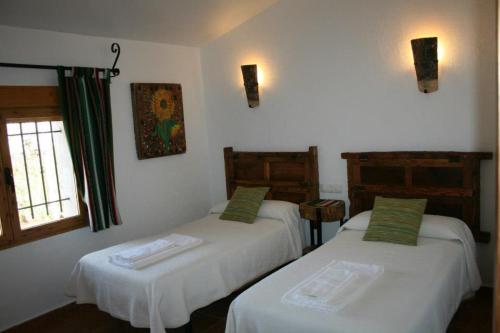 una habitación con dos camas y una ventana en El Molino de Iramala, en Reolid
