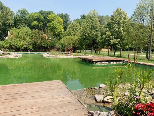 a wooden bridge over a pond in a park at Aranykert Apartmanok Vének in Vének