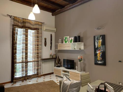 a living room with a window and a table and chairs at Casa nel Vicolo in Palermo