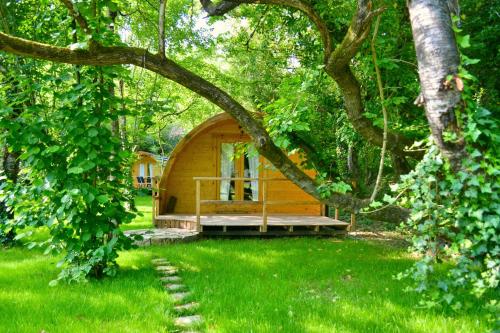 a small wooden cabin in the middle of a yard at Glamping Dragonja River in Šmarje