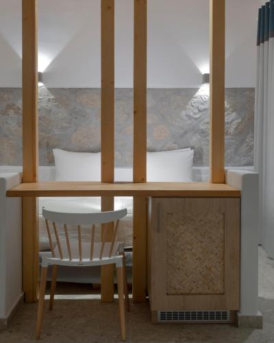a wooden table with a chair and a desk at Mykonos Essence Adults Only in Ornos