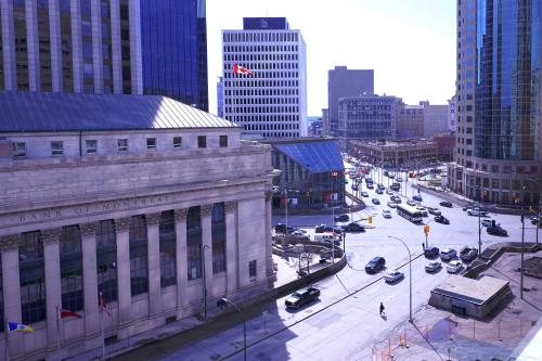 a busy city street with traffic in a city with tall buildings at Fairmont Winnipeg in Winnipeg