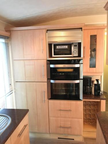 una cucina con forno e microonde di Prachtige Luxe chalet op de Veluwe nabij Hoenderloo a Hoenderloo