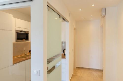 a kitchen with white walls and a sliding glass door at Pine Tree Apartment Zanetic in Blato