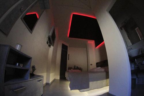 Una habitación con luces rojas en el techo y una cama en Lightroom en Fenis