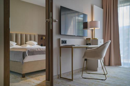 a bedroom with a bed and a desk and a chair at Five Seasons Szklarska Poręba in Szklarska Poręba