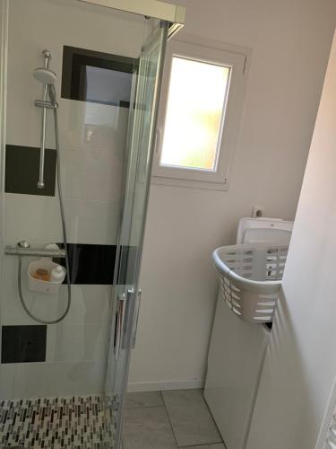 La salle de bains est pourvue d'une douche, d'un lavabo et d'une fenêtre. dans l'établissement Idéale famille, tout y est !, à Dompierre-sur-Besbre