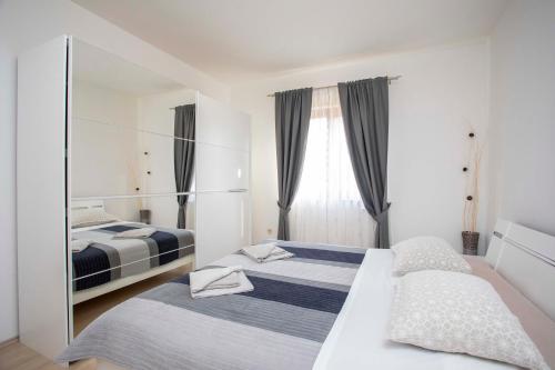 um quarto com 2 camas e um espelho em Apartmani Marica em Plomin