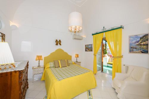 a bedroom with a yellow bed and a couch at Proprietà Antonio 3 unità indipendenti in Positano