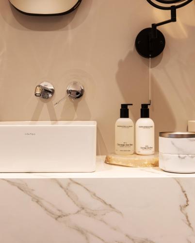 a counter with two bottles of soap and a lamp at Poorter Boutique Hotel Brielle in Brielle