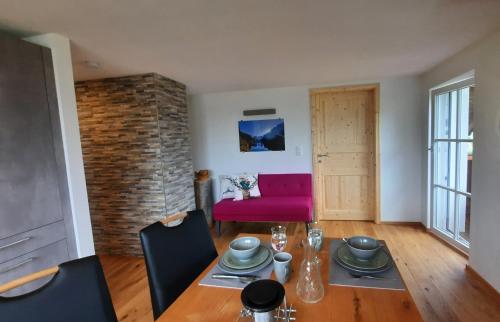 a living room with a table and a pink couch at Kalvarienberg Appartement Gosau in Gosau