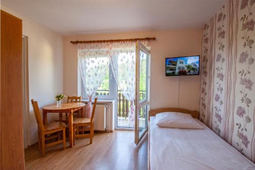 sypialnia z łóżkiem, stołem i oknem w obiekcie Bieszczadzkie Wzgórze w mieście Myczków