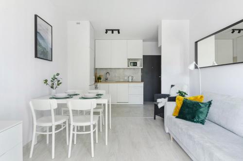 a white living room with a table and a couch at GoldAparts Centrum in Łódź