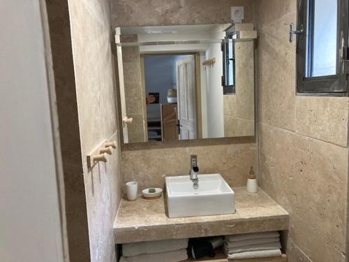 bagno con lavandino bianco e specchio di Mas Galinette a Saint-Andiol