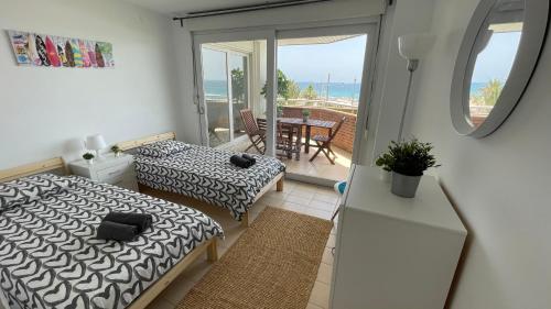 a bedroom with two beds and a balcony with the ocean at Apartments Paradise Lloret in Lloret de Mar