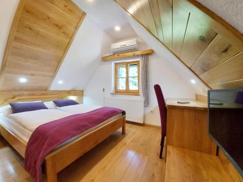 a bedroom with a bed and a desk and a window at Plitvice Ethno House in Jezerce