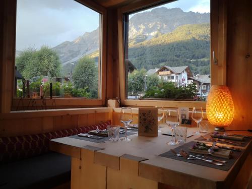 a table with wine glasses in a room with a window at Hotel Nevada in Bormio