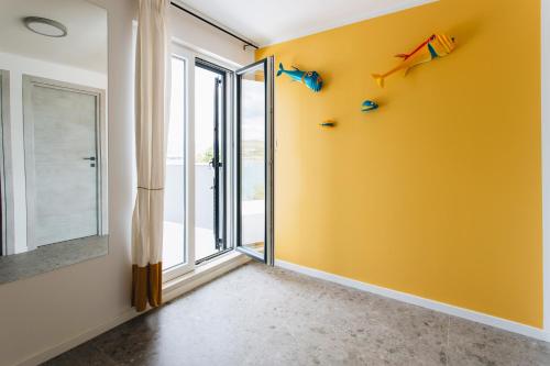 a yellow room with kites on the wall at Villa Magna - seaside villa with pool and sauna in Trogir