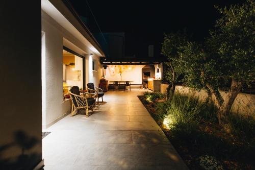 a patio at night with chairs and a table at Villa Magna - seaside villa with pool and sauna in Trogir