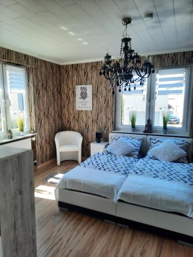 1 dormitorio con cama y lámpara de araña en Haus Heidi, en Rüber