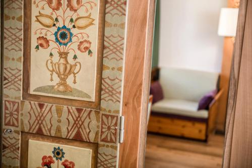 a door with a painting of a vase on a wall at Classic Hotel Am Stetteneck in Ortisei