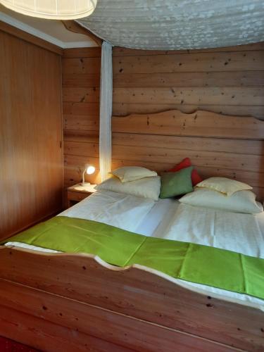a large bed with a wooden headboard in a bedroom at Landgasthof Hubertusstubn in Sankt Michael im Lungau