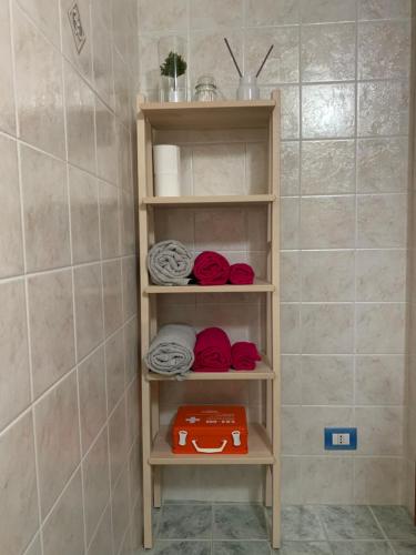 a shelf in a bathroom with red and white towels at Da Nonno Antonio in Santa Teresa di Riva