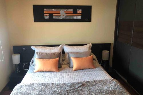 a bedroom with a bed with orange and white pillows at Casa Lopez in Nerja