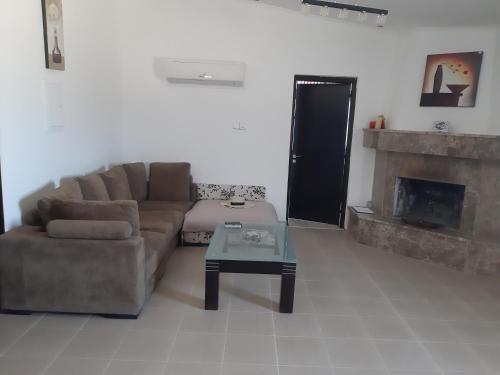 a living room with a couch and a fireplace at Sunset Villa in Nea Paphos
