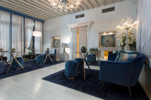 een woonkamer met blauwe stoelen en een kroonluchter bij Relais Venezia in Venetië