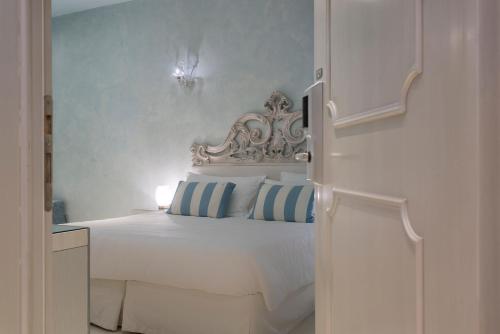 una camera da letto con un letto bianco e pareti blu di Relais Venezia a Venezia