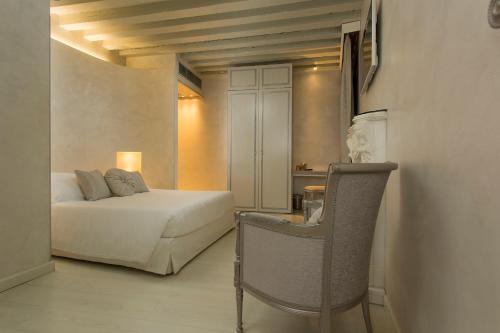 a bedroom with a bed and a table and a chair at Relais Venezia in Venice