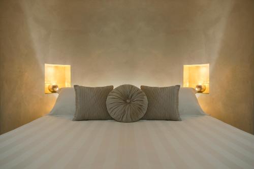 a bed with two pillows and a heart pillow on it at Relais Venezia in Venice