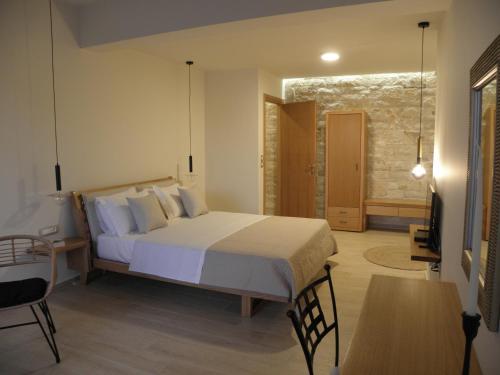 a bedroom with a large bed and a table at Villa Tholos Crete in Kavoúsion