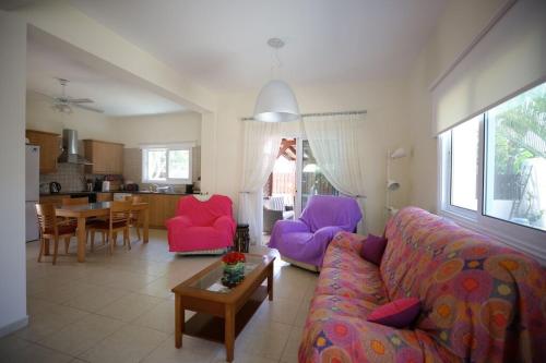 een woonkamer met een bank, stoelen en een tafel bij Unique Beach Luxurious Villas in Ayia Napa