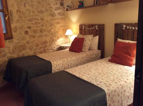 two beds in a hotel room with at La Casa de Baix in Torre del Compte