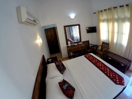 um quarto com uma grande cama branca com almofadas vermelhas em Ramon beach resort em Ambalangoda