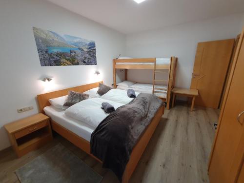 a bedroom with a bed and a bunk bed at Glemmy Appartements inkl Sommercard in Viehhofen