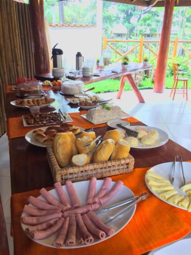 バーハ・グランデにあるPousada Das Roseirasの食べ物やパンの皿が置かれたテーブル
