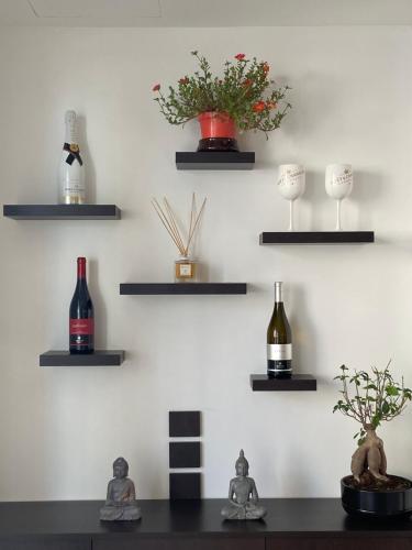 a wall with shelves with bottles and wine glasses at Bonsai in Tropea