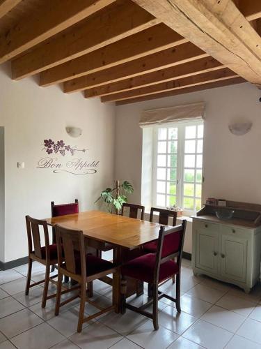 une table de salle à manger et des chaises dans une pièce dans l'établissement Gîte La Roche, à Reffuveille