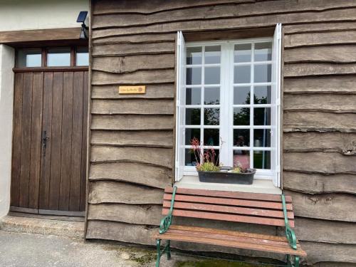 a bench sitting outside of a house with a window at Gîte La Roche in Reffuveille