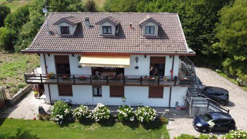 Elle offre une vue aérienne sur une maison dotée d'un balcon. dans l'établissement Villa immersa nel verde a Lanzo d'Intelvi, à Lanzo dʼIntelvi