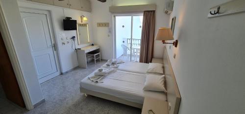 een kleine slaapkamer met een bed met handdoeken erop bij Elarin studios & apartments in Faliraki